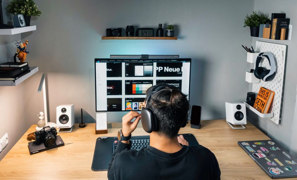 Cozy and organized home office workspace featuring a desktop computer, headphones, and creative decor.