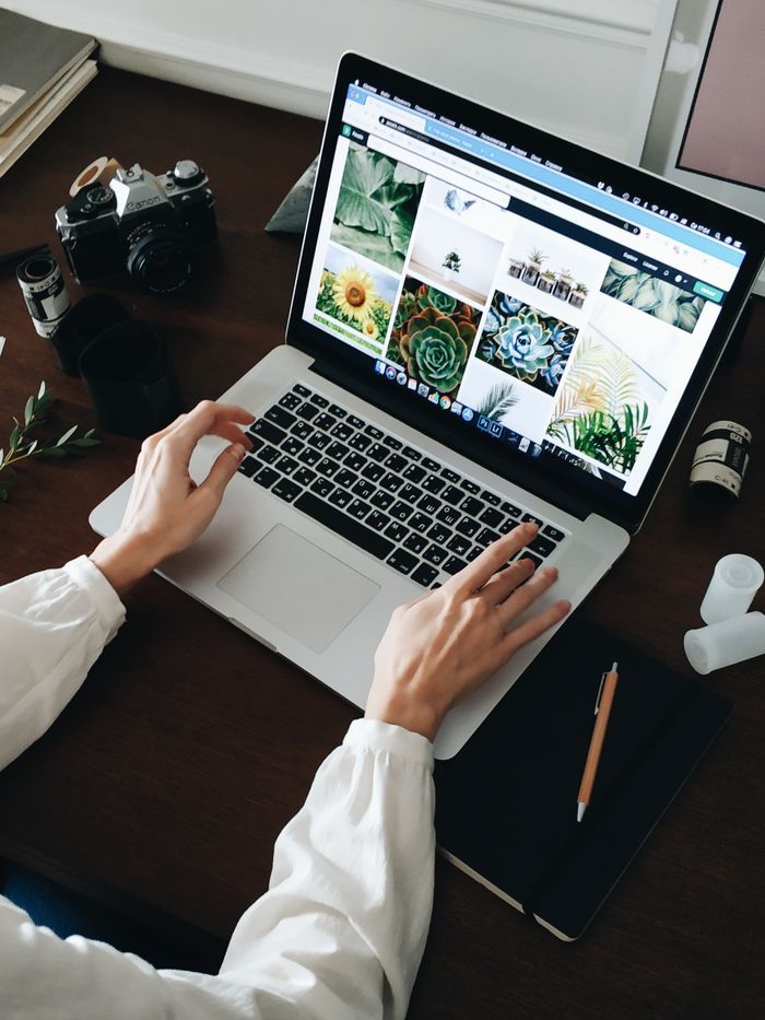 Home Person working on laptop with film camera nearby. Perfect for technology and lifestyle themes.